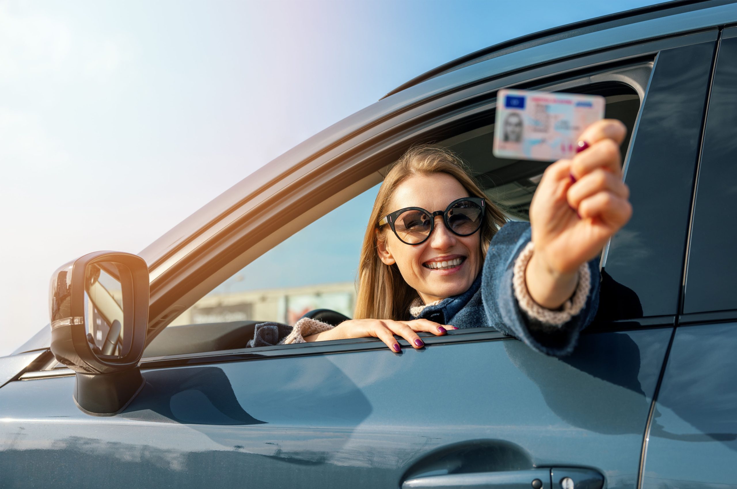 Happy,Woman,Showing,Her,New,Driver,License,Out,Of,Car